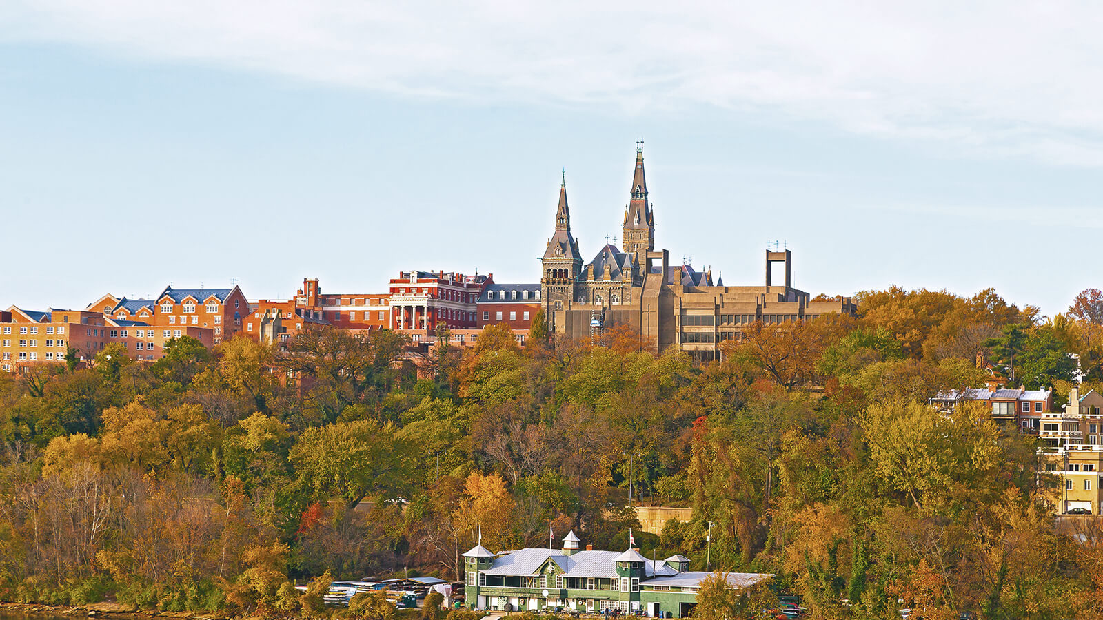 A view of the campus at Georgetown University from up in the air. There are lots of trees boasting Fall-yellow leaves and campus buildings in the distance. 