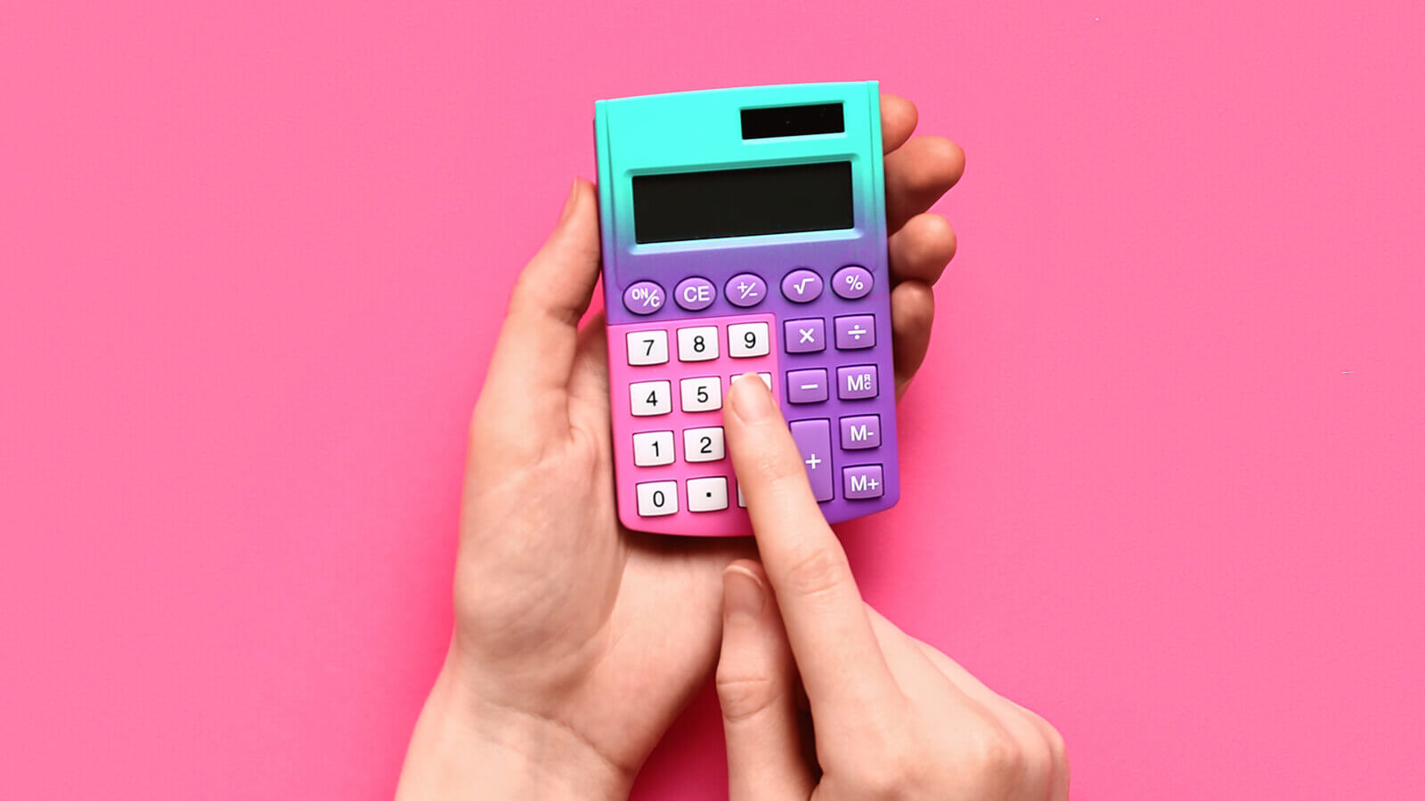a colorful handheld calculator with a hand pressing a button