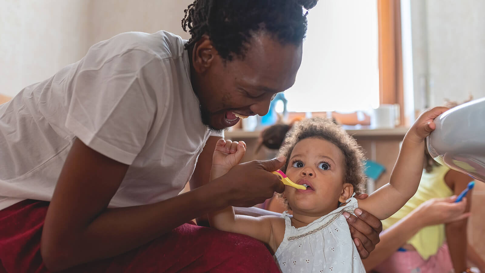 a mother feeds her baby with a plastic spoon