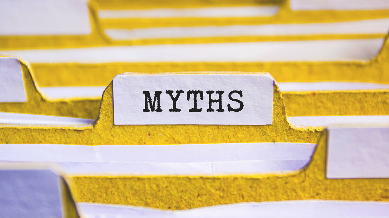a stack of yellow file folders with one labeled myths