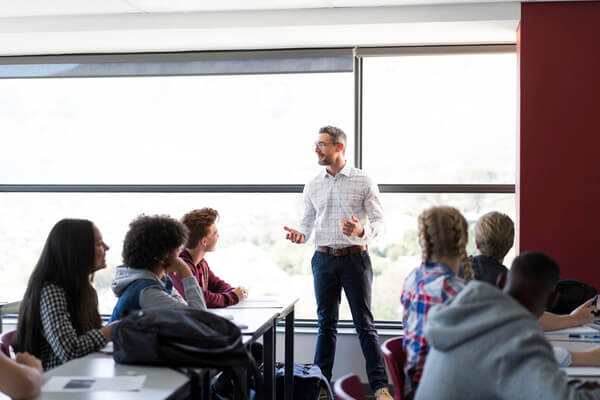 a teacher lectures to a high school classroom
