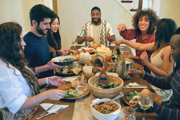 a family sits at a dining table and eats a holiday meal