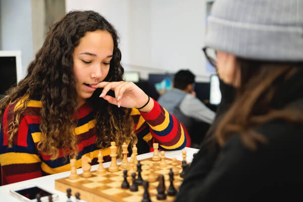 two students play chess in school
