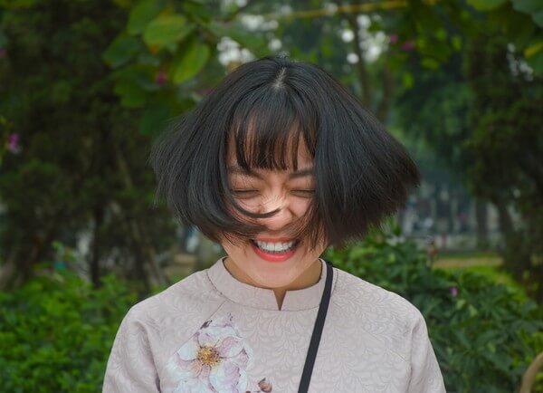 Woman with short hair shaking her head with a smile. 