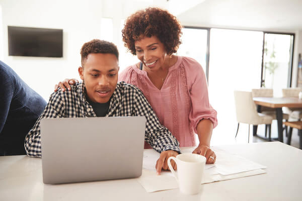 a student and his mom look at scholarships online