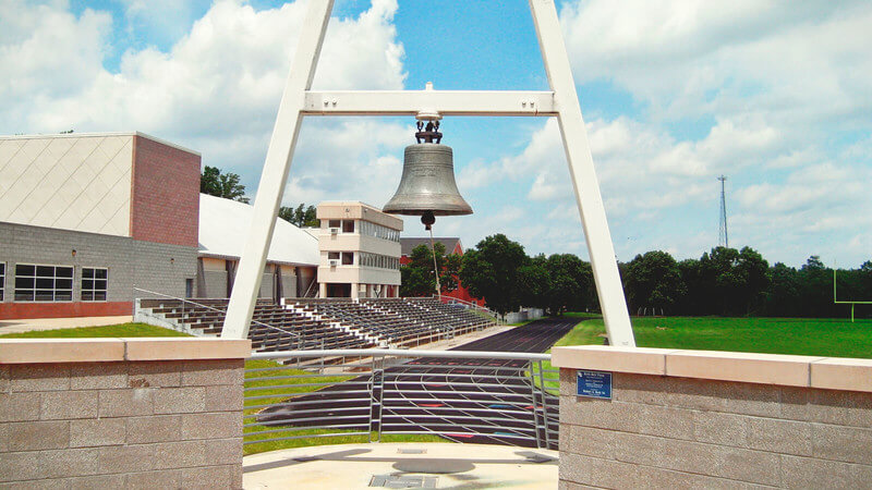 An image of a large bell in a stadium at Hiram College